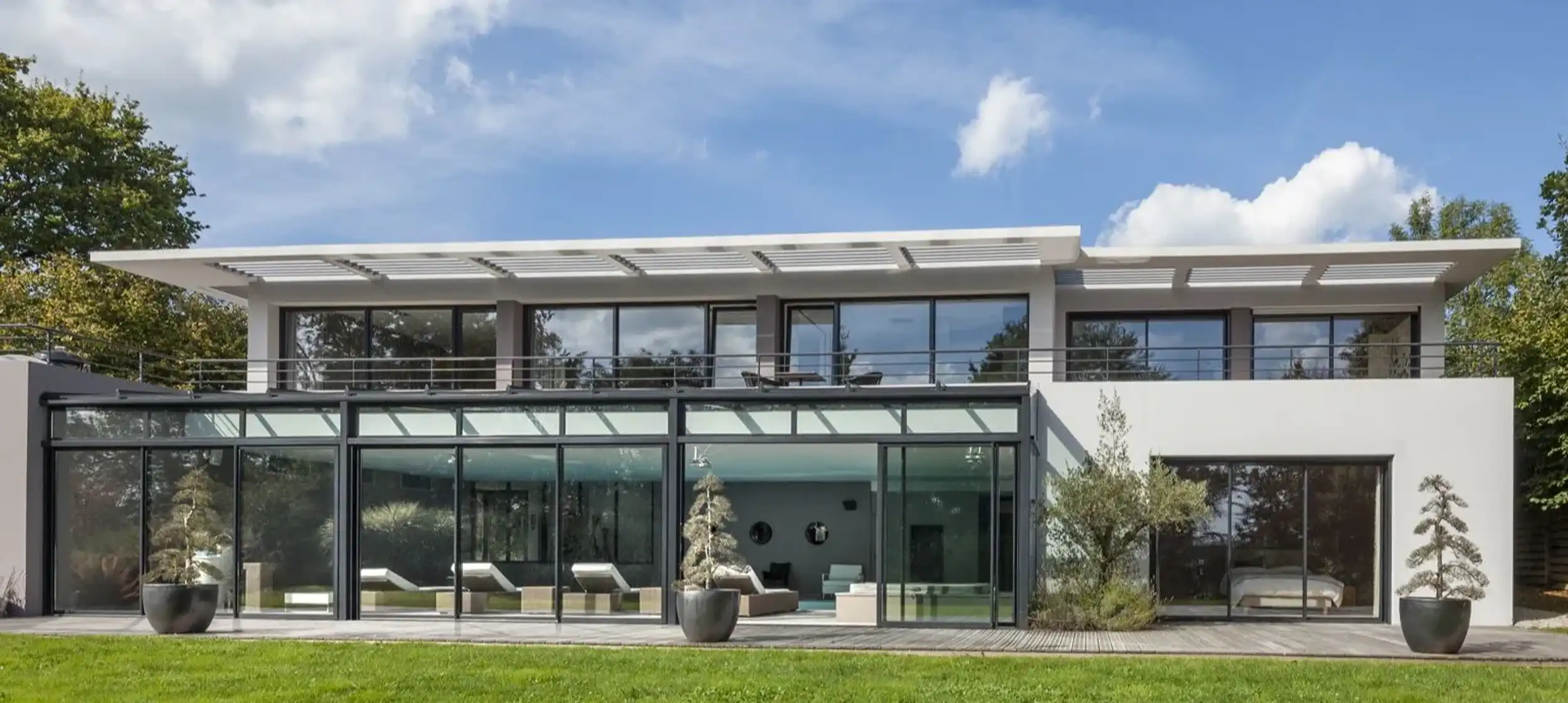 vue de face maison avec espaces vitrés sur jardin DHD Architectes